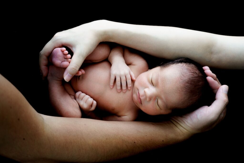 黒背景のニューボーンフォト。新生児の神秘的な写真
